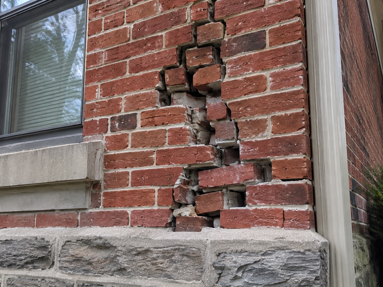Damaged brick wall in need of professional masonry repair